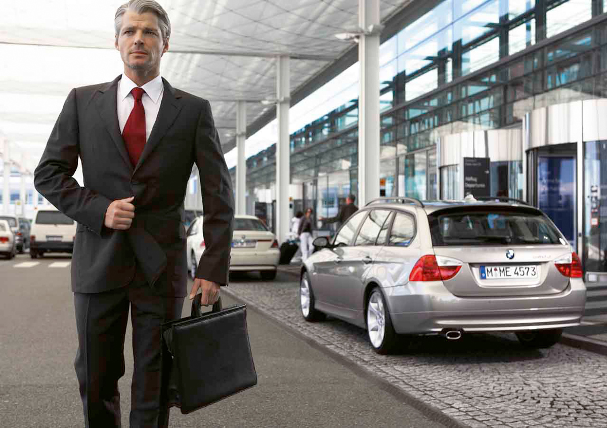 Geschäftsmann läuft an Autos vor der Terminalvorfahrt vorbei