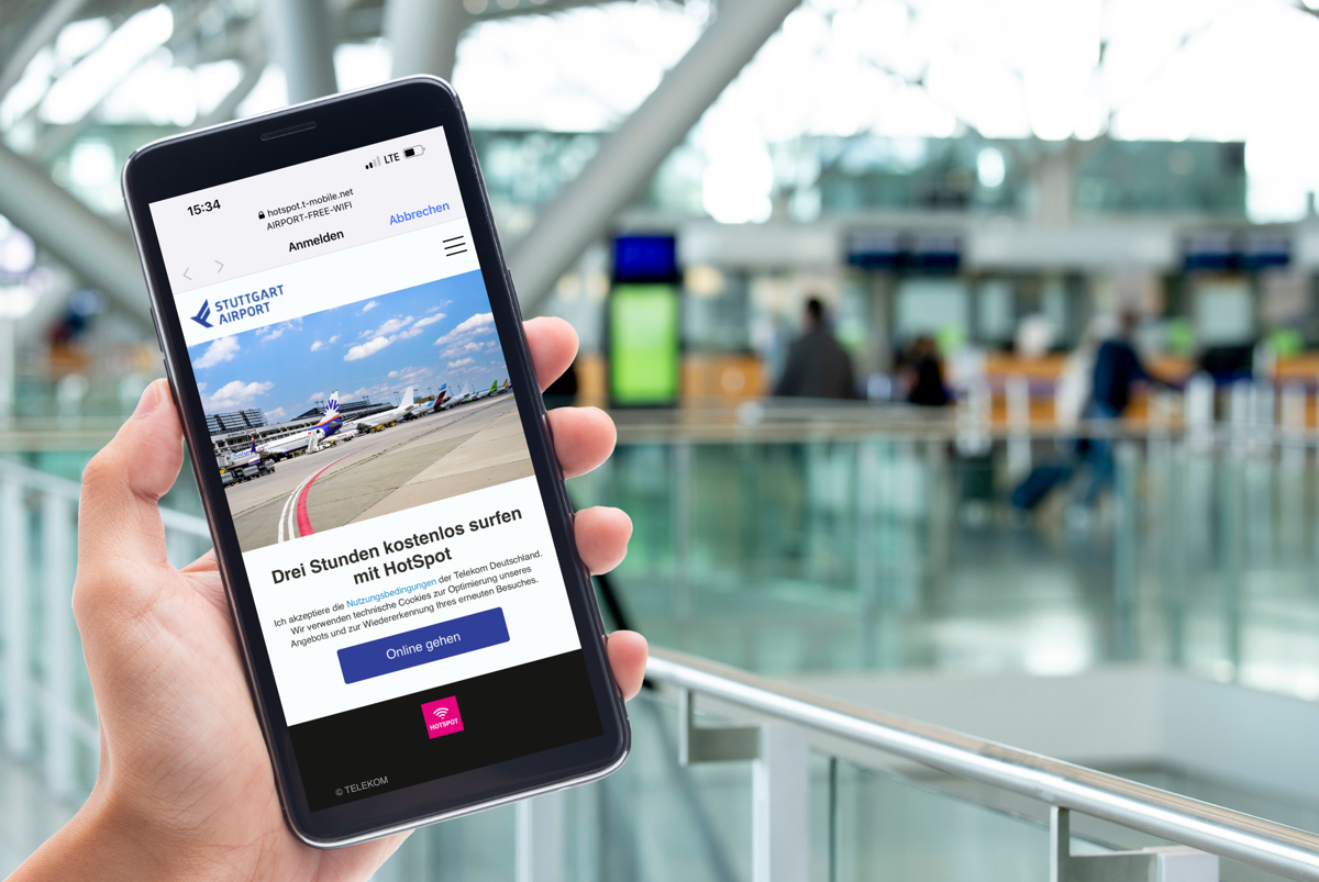 Hand hält Smartphone im Terminal vom Flughafen Stuttgart