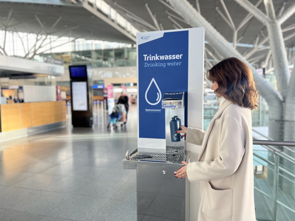 Eine Passagierin füllt sich am Trinkwasser-Spender im Terminal am Flughafen Stuttgart Wasser in eine Flasche.